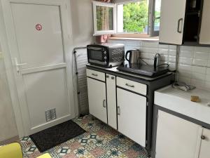 une petite cuisine avec un micro-ondes et un évier dans l'établissement Au calme, proche gare, à Brive-la-Gaillarde 7 autres photos