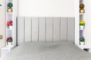 une chambre blanche avec un lit et des étagères avec des fleurs dans l'établissement Silk Road Skyline Tashkent City, à Tachkent 15 autres photos