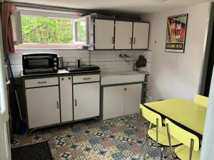 une petite cuisine avec une table et un micro-ondes dans l'établissement Au calme, proche gare, à Brive-la-Gaillarde