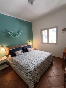 a bedroom with a bed and a blue wall at Le Macine Pugnochiuso Holidays in Vieste