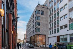a tall building on a city street with buildings at Luxury Holiday Let @ London City in London