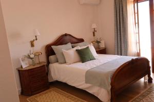 a bedroom with a large bed with white sheets and pillows at Terras da Planície in Ferreira do Alentejo