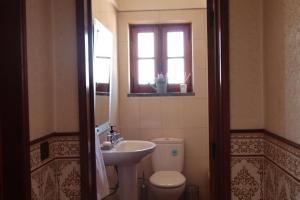 a bathroom with a sink and a toilet and a window at Terras da Planície in Ferreira do Alentejo