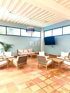 Un vestíbulo con sillas y un cartel de juego en la pared. en Cofradia Lodge, en Villavicencio