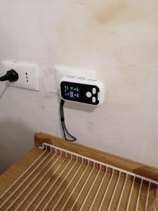 ein Handy ist an einer Wand neben einem Bett befestigt in der Unterkunft Albenga collina ampio quadrilocale con 2 terrazzi in Albenga