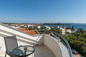 a balcony with a table and a view of the ocean at Apartments Villa Mirela in Petrcane