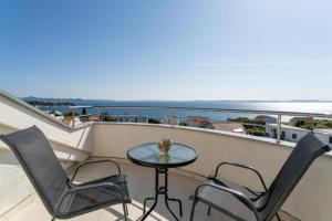 a balcony with a table and two chairs and the ocean at Apartments Villa Mirela in Petrcane