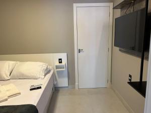 a bedroom with a bed and a flat screen tv at APARTAMENTOS BORA BORA II vila nova 600 METROS DA EXPOVILLE in Joinville