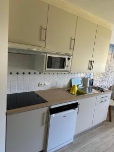 a kitchen with a sink and a microwave at Blutsyde promenade Biaritz 0108 in Bredene +2 photos