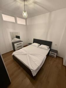 a bedroom with a large bed and a mirror at Riga's Apartment in Prizren +9 photos