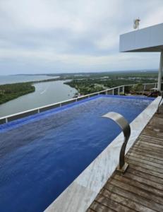 an infinity pool with a view of a river at Flat aconchegante em Recife in Recife
