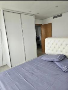 a bedroom with a large bed with a white headboard at Flat aconchegante em Recife in Recife