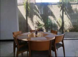 a wooden table and chairs in a room with a window at Flat aconchegante em Recife in Recife +10 photos