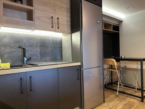 a kitchen with a stainless steel refrigerator and a table at Magic View Luxury Villa 4u - Spiro Spero in Kineta