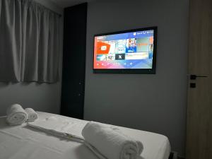 a room with a bed with a tv on the wall at Magic View Luxury Villa 4u - Spiro Spero in Kineta