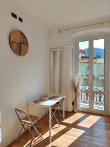 a table and chairs in a room with a balcony at Kalìda Space - Camera matrimoniale in La Spezia