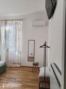 a white room with a mirror and a chair at Kalìda Space - Camera matrimoniale in La Spezia