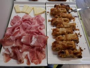 un plato de comida con carne y queso. en Residence Sole, en Trieste