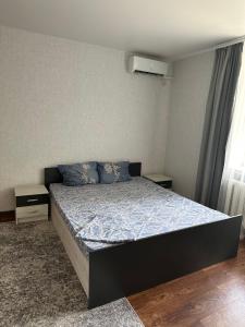 a bedroom with a bed with a blue comforter at Апартаменти на Надпільній поруч з центром in Cherkasy