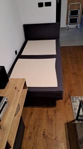 two beds in a room with a wooden table at Apartman NAR Murter in Murter