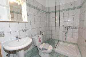 a bathroom with a sink and a toilet and a shower at Hotel Agios Athanasios in Ammoudia