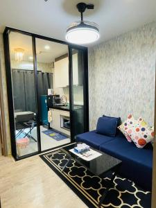 a living room with a blue couch and a mirror at The base Central Pattaya 271 by Numam in Pattaya