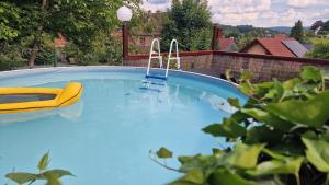 a large swimming pool with a yellow chair in it at Ferienwohnung Berg-Glück, ruhige Lage mit Garten in Schmalkalden
