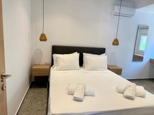 a bedroom with a white bed with two pillows at Sakellis Home 2- Steps to Beach & Town in Kardamaina