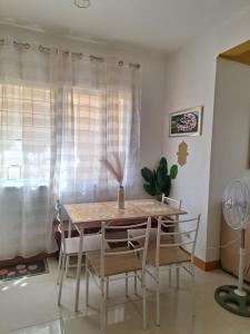 a dining room with a table and chairs and a window at More than Space Staycation in Sampong +14 photos