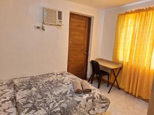 a bedroom with a bed and a desk and a table at More than Space Staycation in Sampong