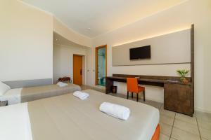 a hotel room with two beds and a desk at Hotel Tirreno in Sapri