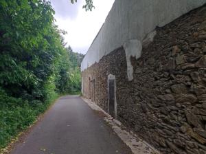 Un muro de piedra con una puerta al costado de un camino. en Karmelita vendégház, en Sopron