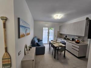 a kitchen and living room with a couch and a table at Grey House1 100m to the beach in Tortoreto Lido