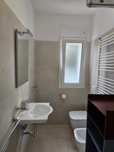 a bathroom with a sink and a toilet and a window at Grey House1 100m to the beach in Tortoreto Lido