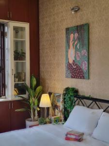 a bedroom with a bed and a painting on the wall at Ả home - Hồ tây, phòng lớn, ban công in Hanoi