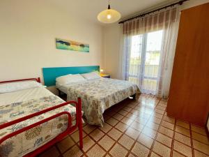 a bedroom with two beds and a window at Spacious apartment near the beach in Porto Santa Margherita di Caorle