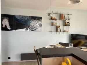 ein Esszimmer mit einem Tisch und einem Gemälde an der Wand in der Unterkunft Bel appartement vue mer in Royan + 1 Foto