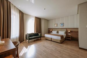 una habitación de hotel con una cama y una silla en City Park Inn Baku, en Baku 60 fotos más