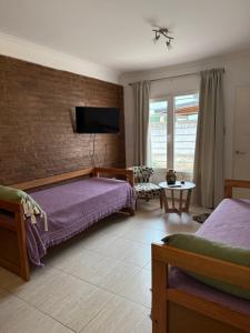 ein Schlafzimmer mit zwei Betten und einer Ziegelwand in der Unterkunft Complejo Pampa in Santa Rosa