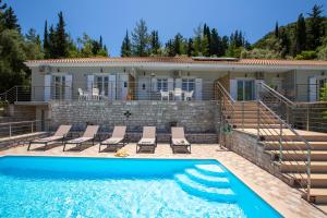 a villa with a swimming pool and a house at Theros Apartment 1 in Yénion