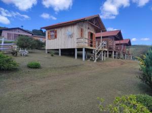 a large wooden house with a porch at Paraíso Dos Cânions in Bom Jardim da Serra