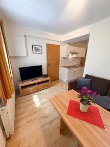 una sala de estar con un sofá y una mesa en Ferienwohnung Haus Seeblick Geltow, en Schwielowsee