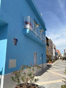 a blue building with a balcony on a street at Casa Azul in Málaga