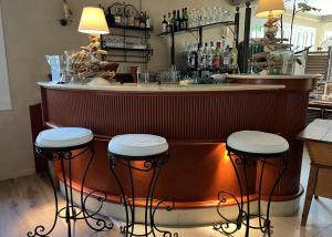 a bar with three stools in front of a counter at Hôtel Beau Site - Cap d'Antibes in Antibes