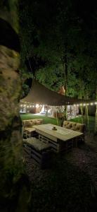 a picnic table with couches and a tent with lights at Domek Brzozowa Kropelka in Dąbrówno