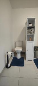 a bathroom with a white toilet and a blue rug at Appartement cosy à Chartres avec balcon de 50 m² in Chartres +4 photos