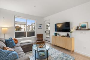 a living room with a couch and a tv at Chic Condo with Stylish Amenities in White Rock in Surrey
