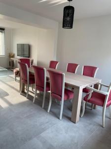 una sala conferenze con tavolo in legno e sedie rosse di La maison de Julien a Bourbourg Altre 10 foto