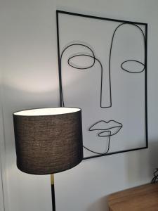 lampa przed obrazem kobiety w obiekcie Appartement de charme Rouen w Rouen