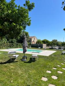 una piscina con sombrilla, 2 sillas y una mesa en Habitat Luxury Suites, en Bellona